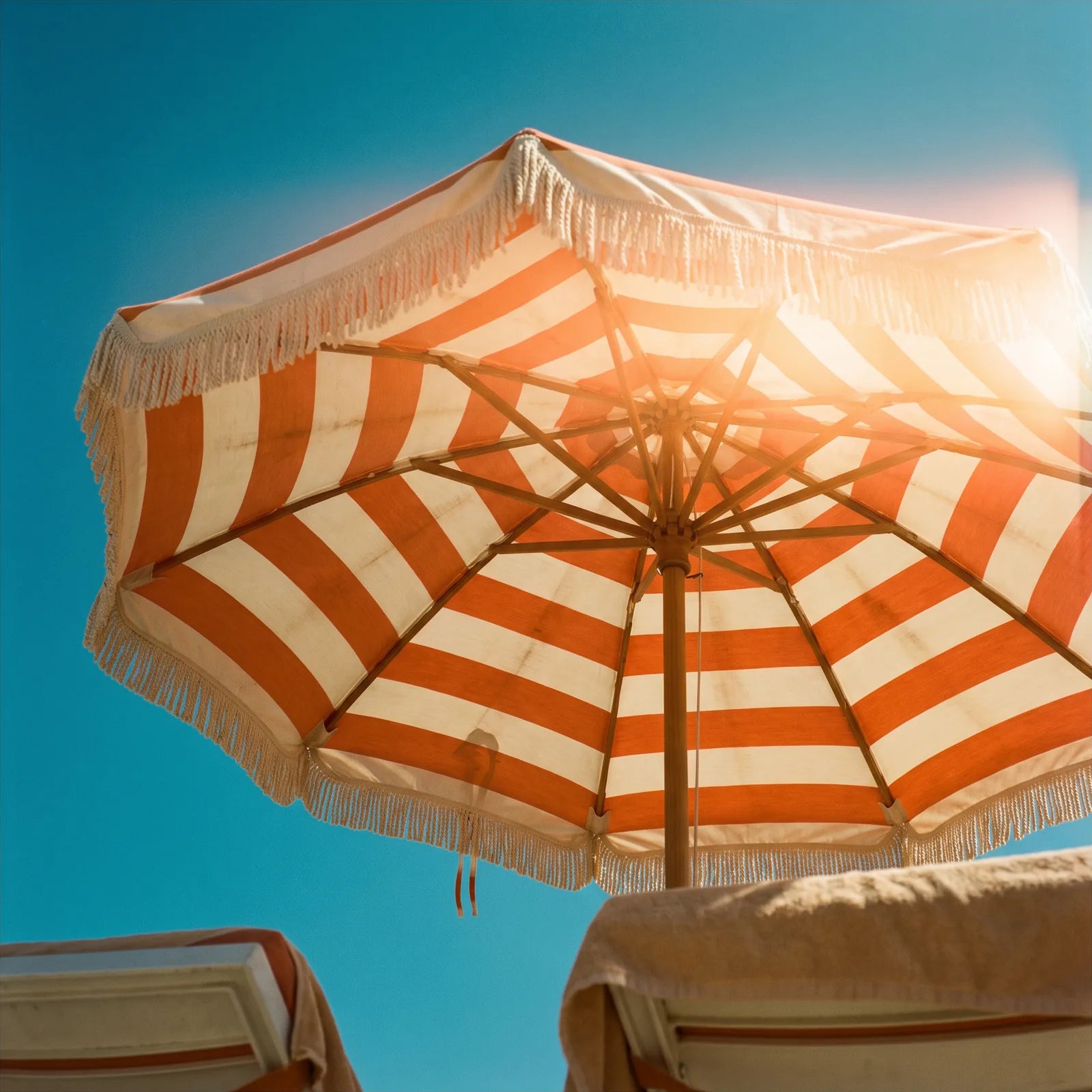 Looking up through an orange and white striped beach umbrella