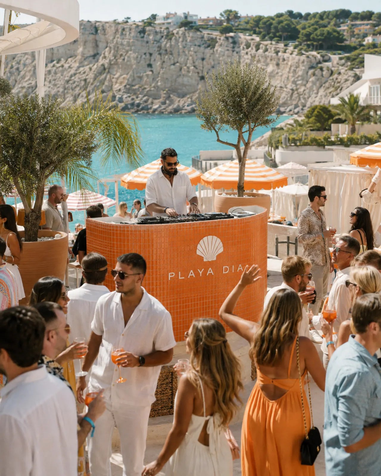 Guests gathering around the PLAYA DIA DJ booth at the beach club